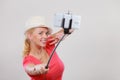 Woman taking picture of herself with phone on stick Royalty Free Stock Photo