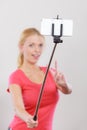 Woman taking picture of herself, phone on stick Royalty Free Stock Photo