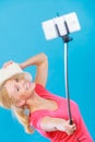 Woman taking picture of herself with phone on stick Royalty Free Stock Photo