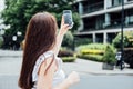 Woman taking picture of the new house with mobile phone. Homebuyer using smartphone to photograph the apartment