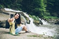 Woman taking picture on the phone of waterfall on background Royalty Free Stock Photo