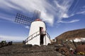 Woman taking a picture with a smartphone in front of a traditional windmill in the cactus garden on Lanzarote Royalty Free Stock Photo