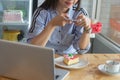 Woman taking picture of strawbery cake with smartphone