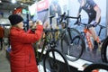 Woman taking picture of a tag with technical characteristics of bikes presented on a stand
