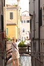 A woman is taking a picture of Venice, Italy