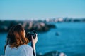 woman taking pictures on camera sea in mountains back view Royalty Free Stock Photo