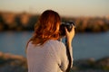 woman taking pictures on camera sea in mountains back view Royalty Free Stock Photo