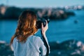 woman taking pictures on camera sea in mountains back view Royalty Free Stock Photo