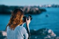 woman taking pictures on camera sea in mountains back view Royalty Free Stock Photo