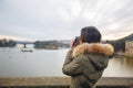 Woman is taking pictures on the Charles bridge in Prague. Young beautiful girl tourist stands on the Charles Bridge in Prague in Royalty Free Stock Photo