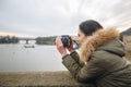 Woman is taking pictures on the Charles bridge in Prague. Young beautiful girl tourist stands on the Charles Bridge in Prague in Royalty Free Stock Photo