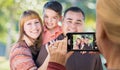 Woman Taking Photo of A Mixed Race Family with Her Smart Phone