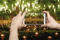 Woman Taking pictures on mobile smart phone showing Yee Peng Lighting Loy Krathong in phan Tao temple, Chiangmai, Thailand