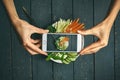 Woman taking pictures phobuddha bowl with vegan food, fried chickpeas, rice noodles with wegetables