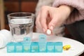 Woman taking pill from plastic container at white table indoors, closeup Royalty Free Stock Photo