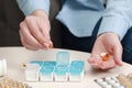 Woman taking pill from plastic container at white table indoors, closeup Royalty Free Stock Photo