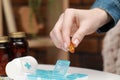 Woman taking pill from plastic container at white table indoors, closeup Royalty Free Stock Photo