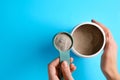 Woman taking scoop of protein from jar on light blue background, top view. Space for text Royalty Free Stock Photo