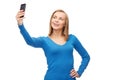 Woman taking self picture with smartphone camera Royalty Free Stock Photo