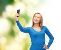Woman taking self picture with smartphone camera Royalty Free Stock Photo