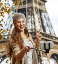 Woman taking selfie with cellphone and showing victory in Paris Royalty Free Stock Photo