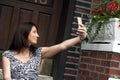 Woman taking a selfie in front of her door Royalty Free Stock Photo