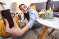 Woman taking selfie with her dog while celebrating his birthday Royalty Free Stock Photo