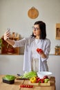 Woman taking selfie or makes a video lesson about cooking, on cellphone Royalty Free Stock Photo