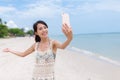 Woman taking selfie by mobile phone in beach Royalty Free Stock Photo