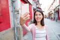 Woman taking selfie by mobile phone in Macau city Royalty Free Stock Photo