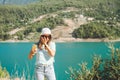 Woman taking selfie on mobile phone of mountains lake background. Traveler female having video chat on cellphone on the Royalty Free Stock Photo