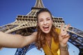 Woman taking selfie and showing victory against Eiffel tower Royalty Free Stock Photo