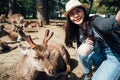 Woman taking selfie with sleeping deer