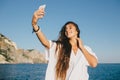 Woman taking selfie on smart phone on yacht. Royalty Free Stock Photo