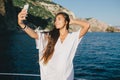 Woman taking selfie on smart phone on yacht. Royalty Free Stock Photo