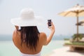 Woman taking selfie with smartphone on beach