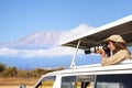 Woman taking shots during Kenyan safari game drive