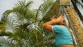 Woman taking a shower in garden near hotel. Girl in blue swimsui Royalty Free Stock Photo