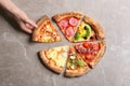 Woman taking slice of delicious pizza at marble table, top view Royalty Free Stock Photo