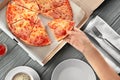 Woman taking slice of tasty pizza from box, top view Royalty Free Stock Photo