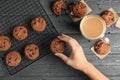 Woman taking tasty chocolate chip cookie from cooling rack on wooden background Royalty Free Stock Photo