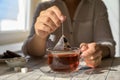 Woman taking tea bag out of cup at table indoors, closeup Royalty Free Stock Photo