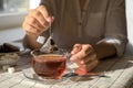 Woman taking tea bag out of cup at table indoors, closeup Royalty Free Stock Photo