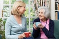 Woman Taking Time To Visit Senior Female Neighbor And Talk