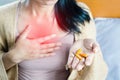 Woman taking turmeric pill, or curcumin herb medicine for GERD, treatment for heartburn from acid reflux disease