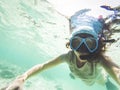 woman taking an underwater selfie while snorkeling in crystal clear tropical water Royalty Free Stock Photo