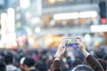 A woman taking video at Shibuya crossing. full of people, crosswalk cityscape, Pedestrians cross at Shibuya Crossing. Royalty Free Stock Photo