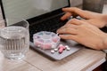 Woman taking Daily vitamins white working on laptop Organizer weekly shots Closeup of medical pill box with doses of