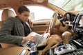 Woman talking on cellphone and using laptop in car Royalty Free Stock Photo