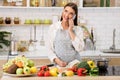 Woman talking on cellphone and writing new recipes